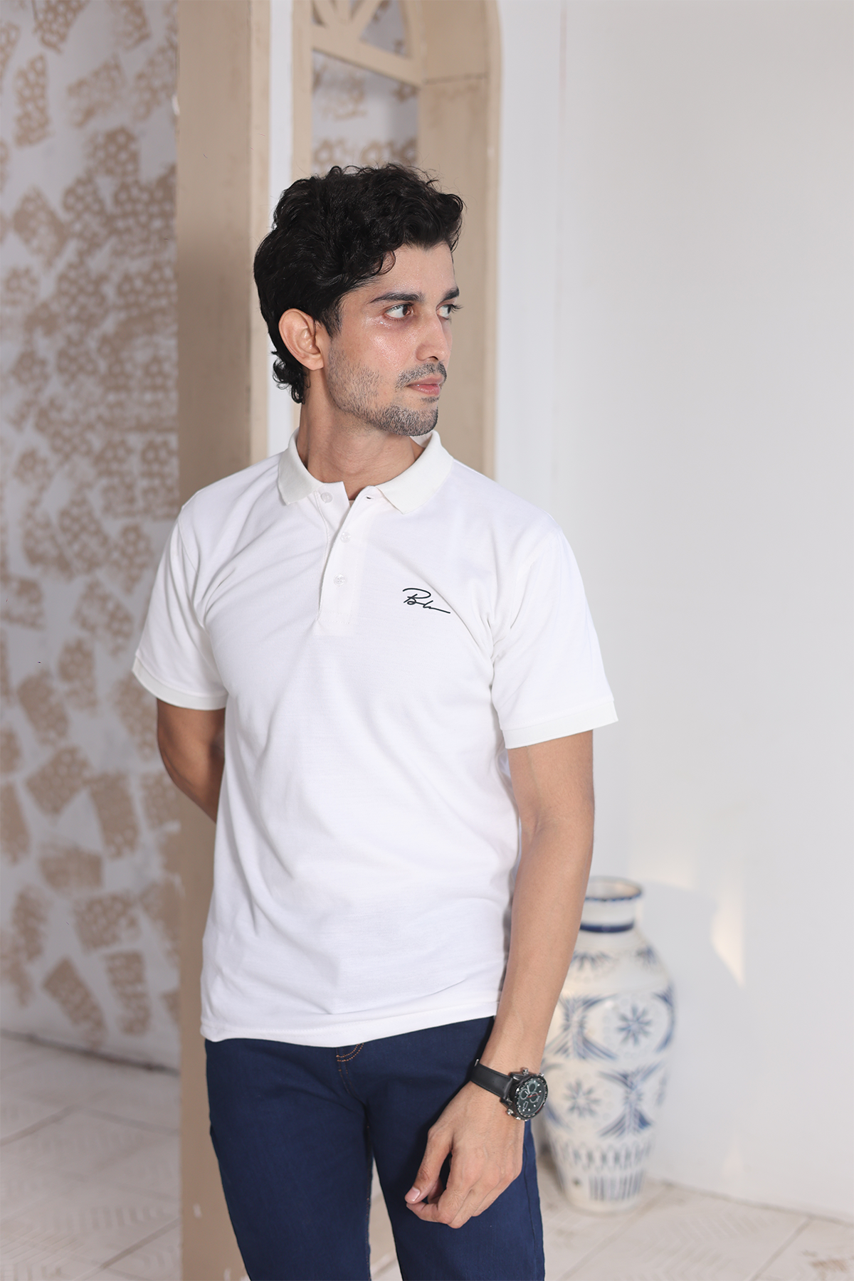 Men's white polo shirt with short sleeves, buttoned collar, and chest logo