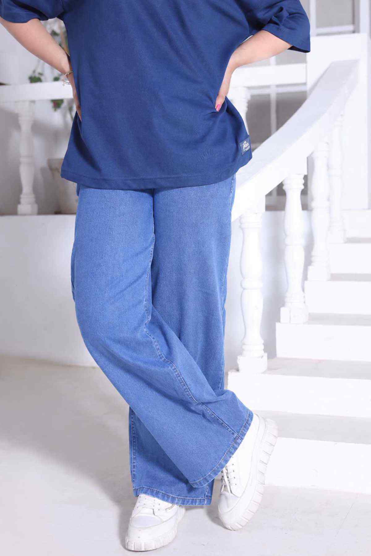 Denim blue T-shirt hem with light blue wide-leg jeans and white sneakers