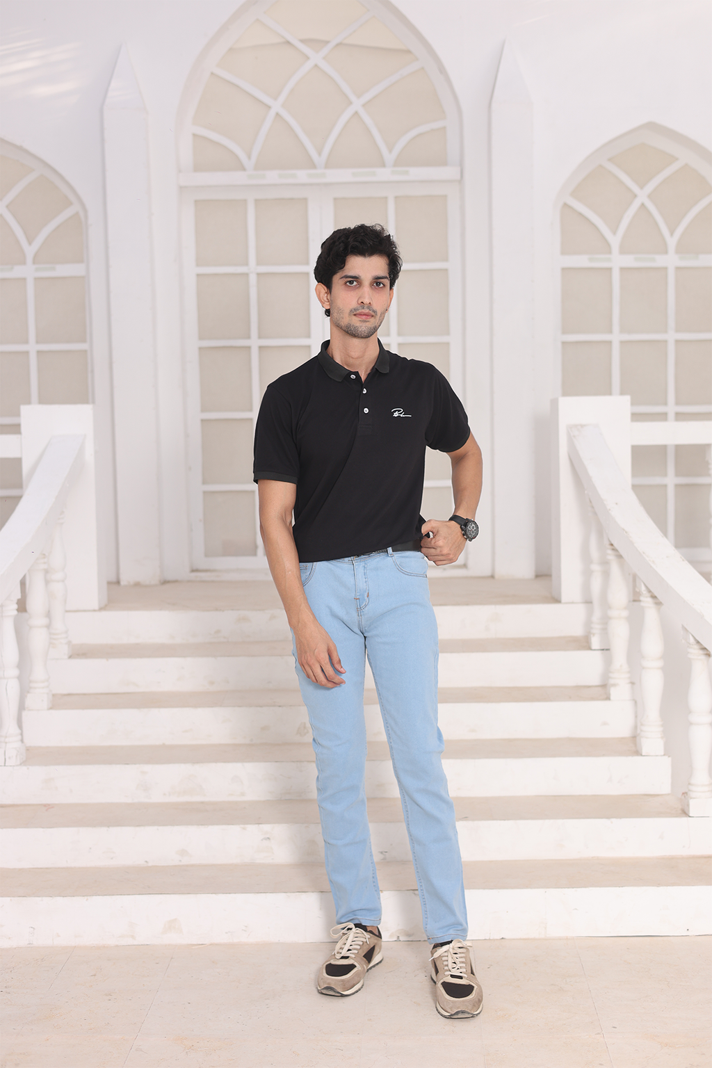 Black polo shirt with open collar, chest logo, and short sleeves