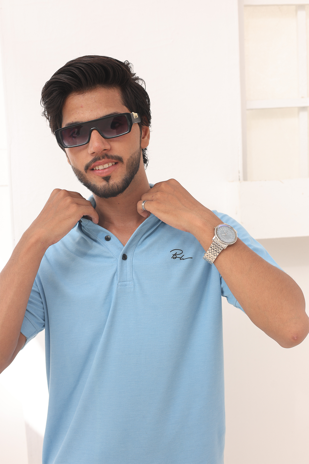 Sky blue polo shirt with embroidered chest logo and buttoned collar
