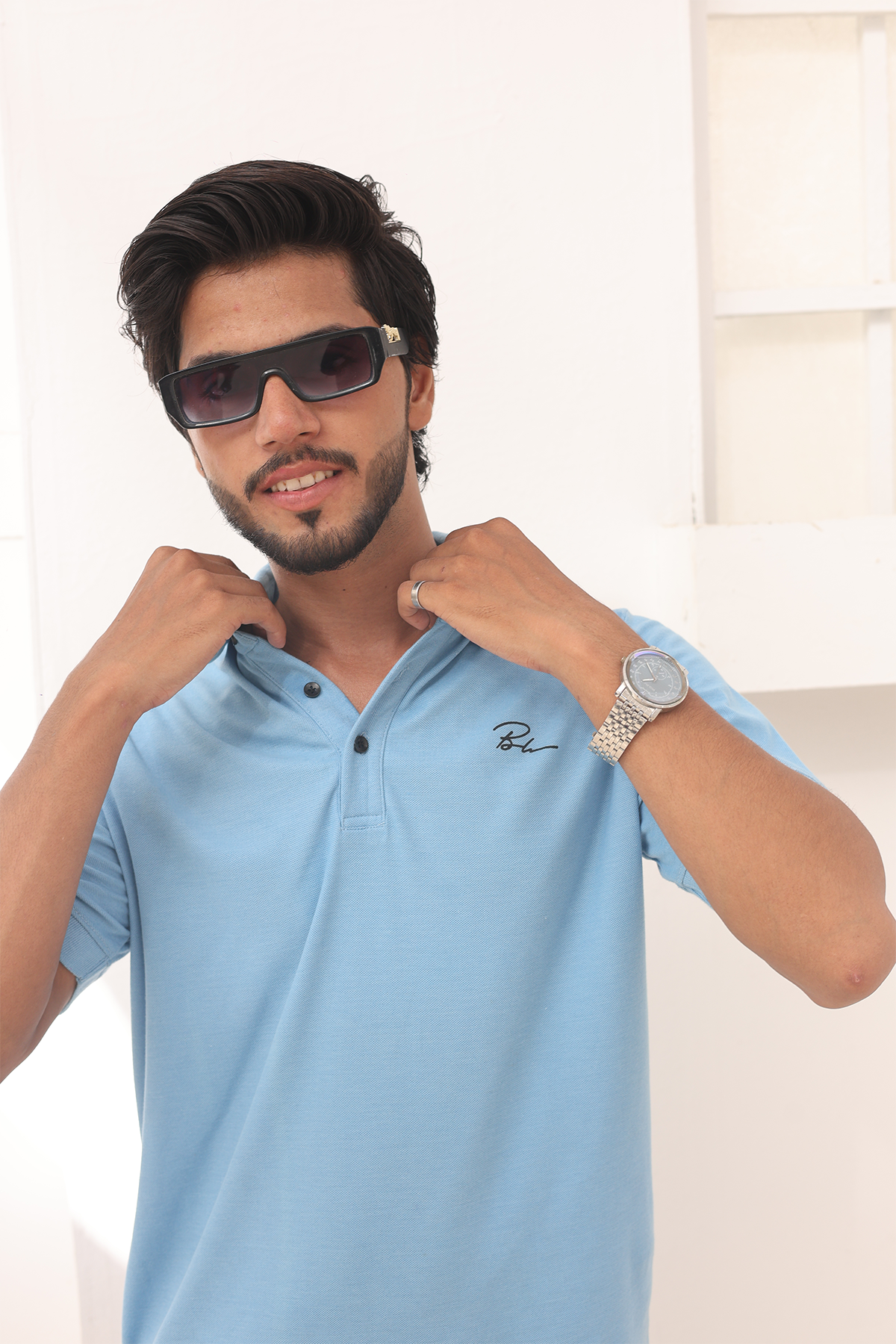 Sky blue polo shirt with embroidered chest logo and buttoned collar
