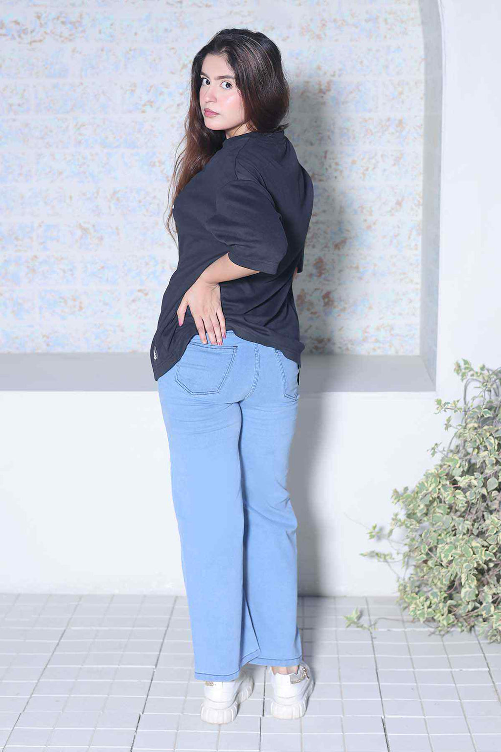 Beleri London black logo T-shirt with light blue wide-leg pants, side view