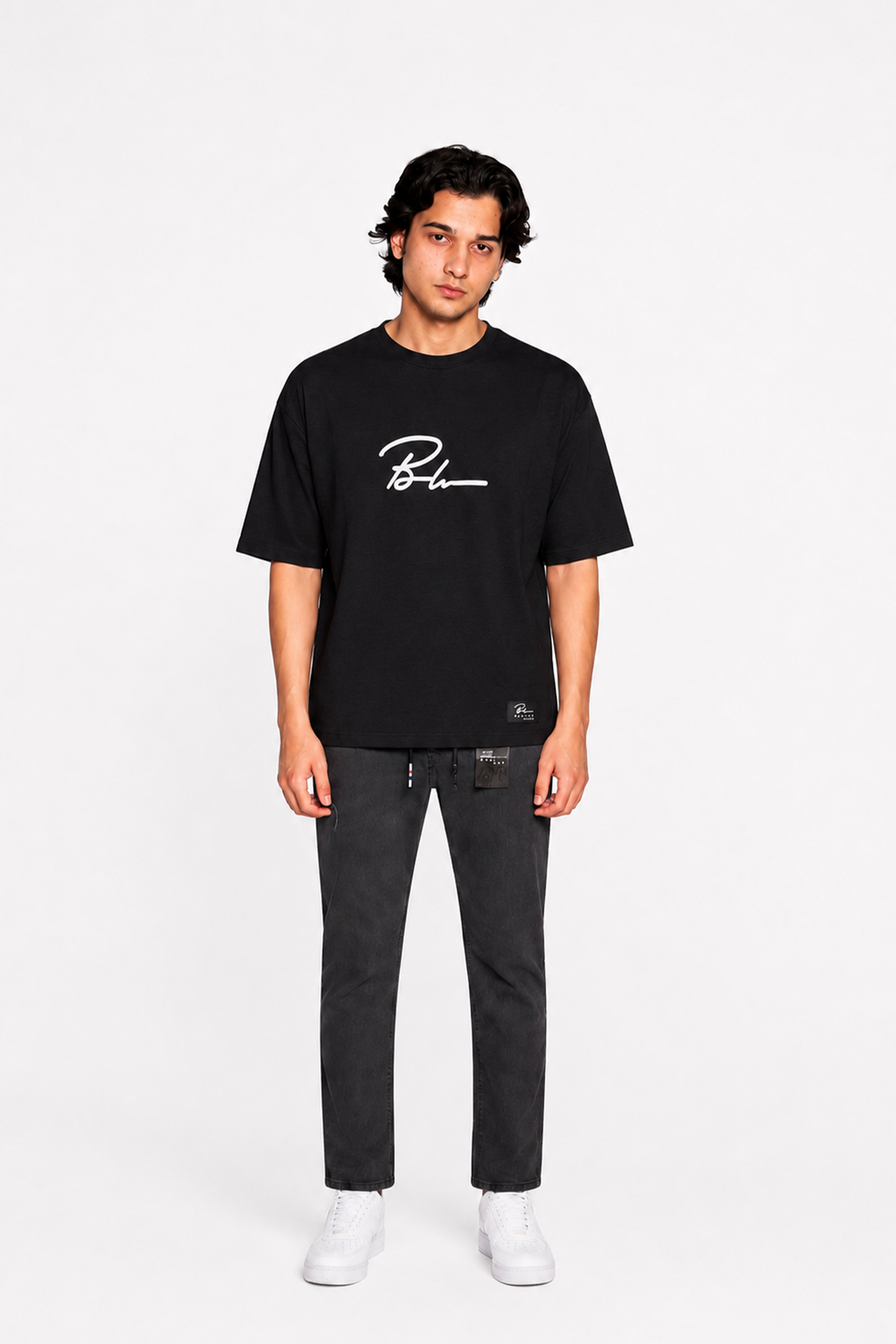 Jet black graphic T-shirt and black jogger pants, white sneakers