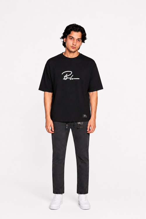 Jet black graphic T-shirt and black jogger pants, white sneakers