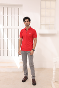 Red polo shirt with short sleeves, button placket, and small chest logo worn by model.